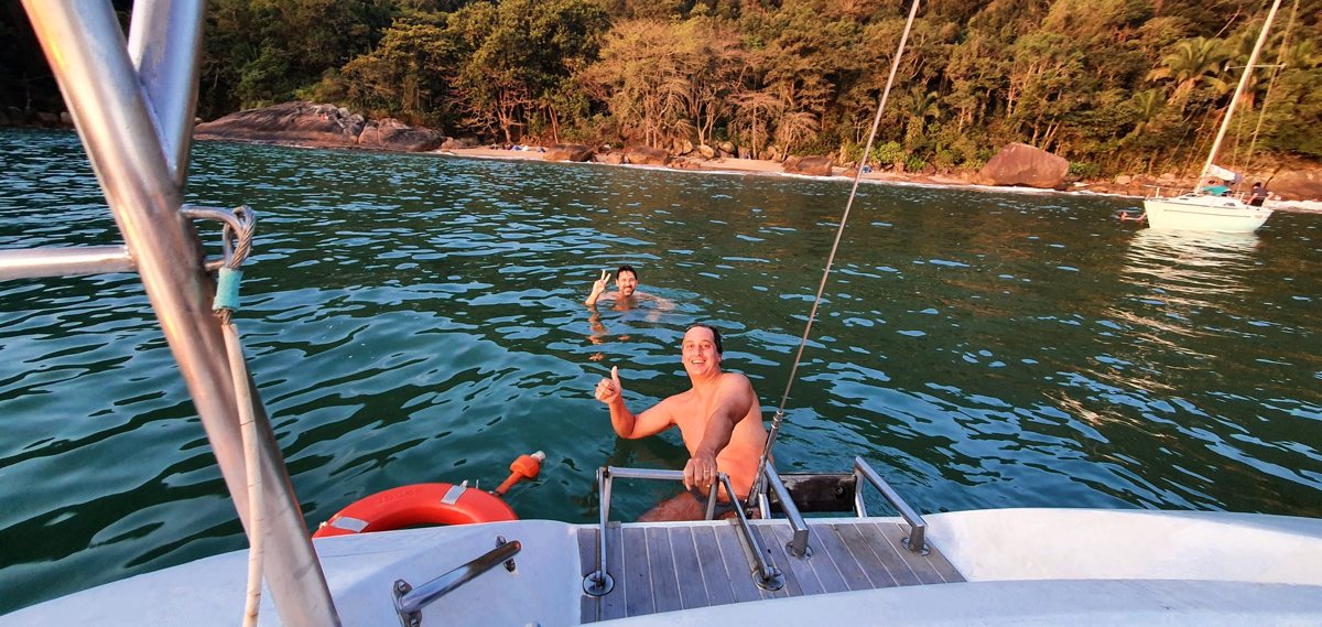 Banho de mar junto à popa do Éolo, em uma enseada com mata ao fundo