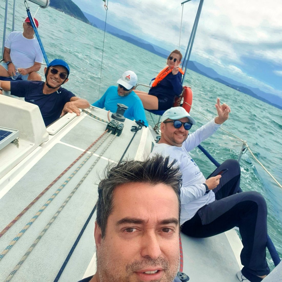 Equipe do Éolo a bordo, sorrindo, durante uma regata