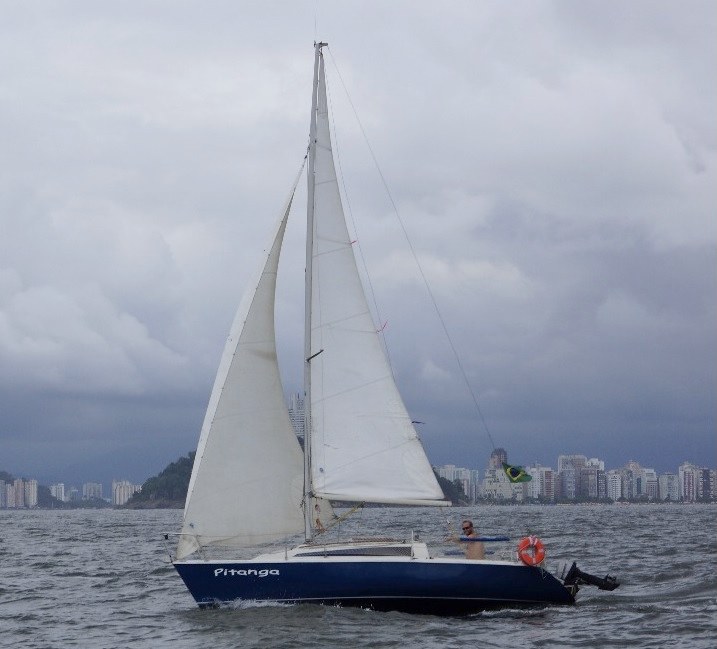 O Pitanga navegando em frente à cidade, sob céu carregado